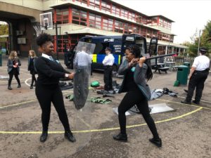 One student with a truncheon hits a police shield held by another student.